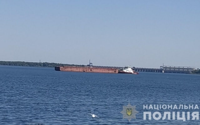 На Днепре рыбацкую лодку затянуло под баржу